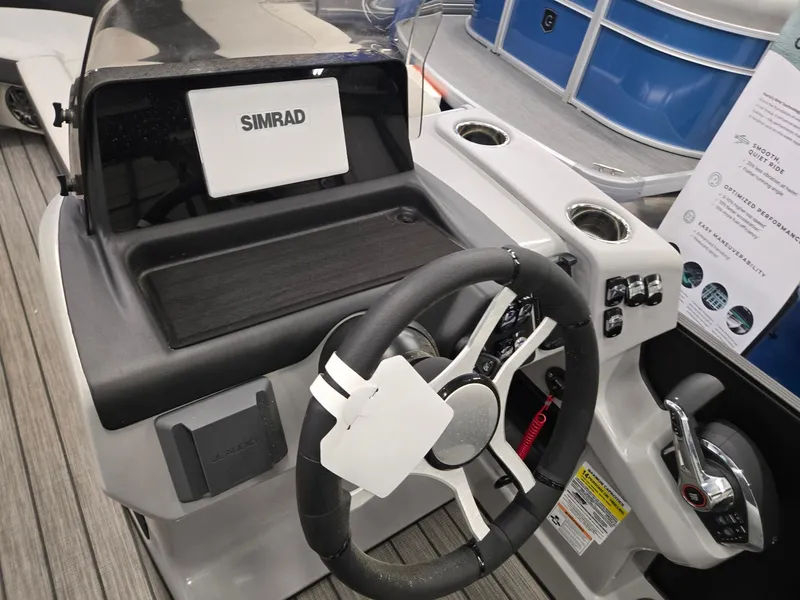 Slide: The Image of 2024 Harris Cruiser 230 boat dashboard with steering wheel and Simrad display. - 13