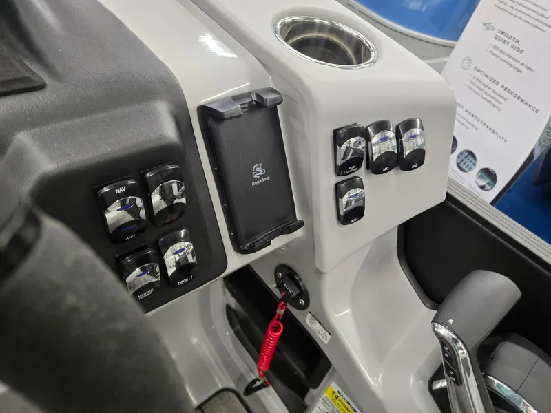 Slide: The Image of 2024 Harris Cruiser 230 dashboard with controls, cup holder, and phone mount. - 16