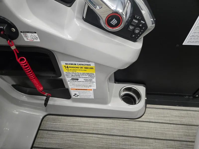 Slide: The Image of 2024 Harris Cruiser 230 boat console with controls, cup holder, and capacity label. - 17