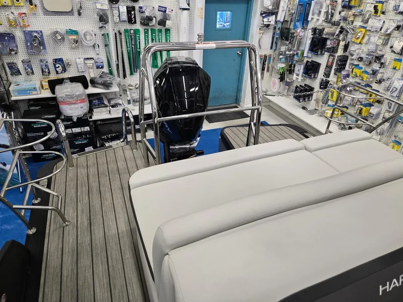Slide: The Image of 2024 Harris Cruiser 230 boat interior with motor, displayed in a marine supply store. - 19