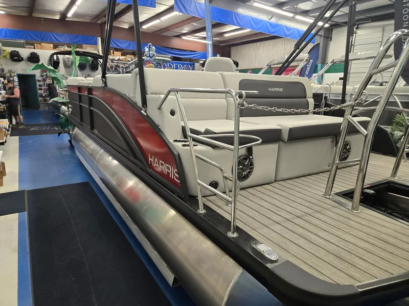 Slide: The Image of 2024 Harris Cruiser 230 pontoon boat displayed in showroom, featuring sleek design and comfortable seating. - 3
