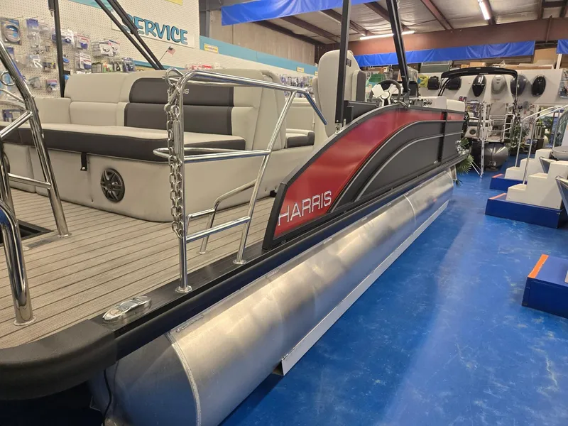 Slide: The Image of 2024 Harris Cruiser 230 pontoon boat in showroom, featuring sleek design and comfortable seating. - 6