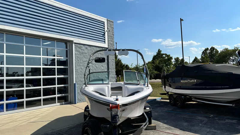 Slide: The Image of 2005 Correct Craft SV211 Nautique Air boat outside a garage on a sunny day. - 3
