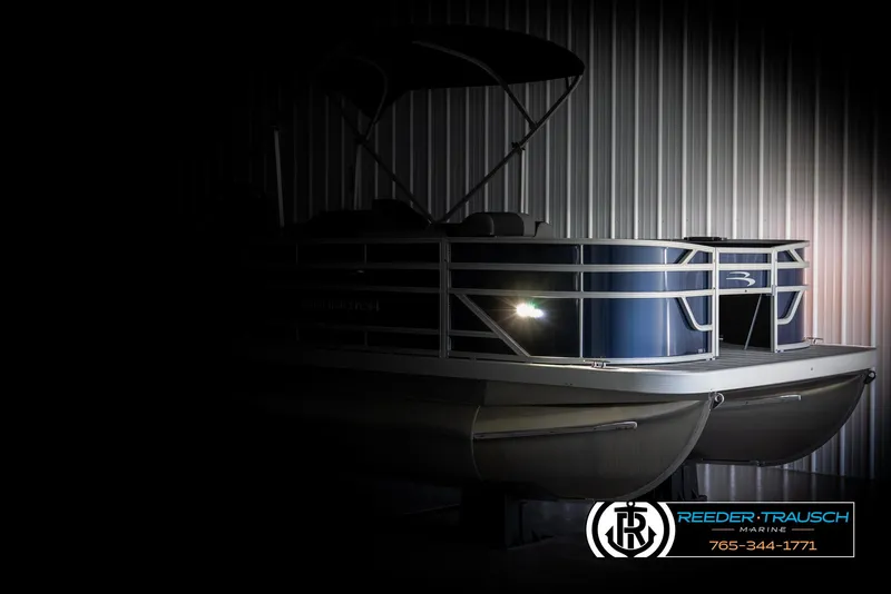 Slide: The Image of 2025 Bennington 188 SSSE pontoon boat in dimly lit showroom. - 4