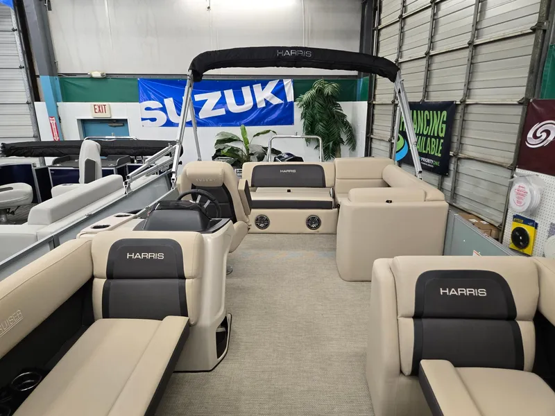 Slide: The Image of 2025 Harris Cruiser 210 pontoon boat interior with plush seating in showroom. - 2