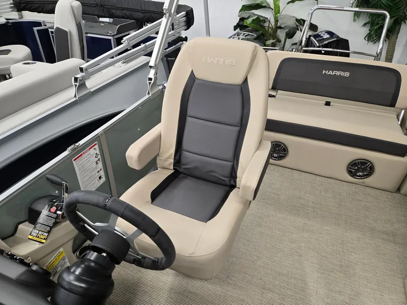 Slide: The Image of 2025 Harris Cruiser 210 boat interior with beige and gray seating, steering wheel, and controls. - 6