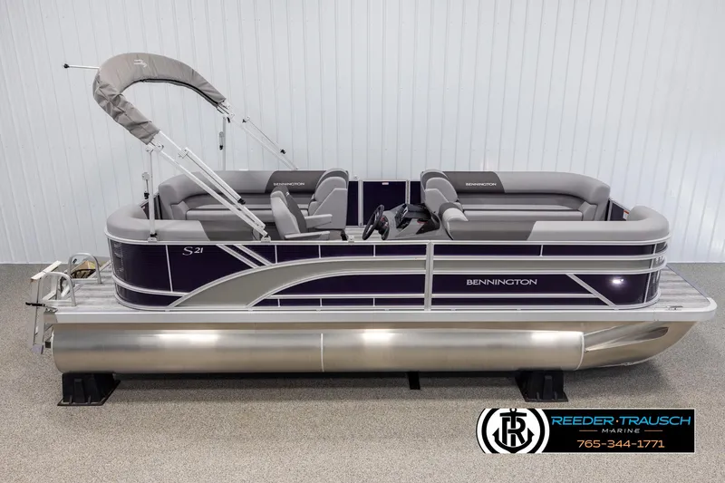 The Image of 2025 Bennington 21 SSRSE pontoon boat with gray seating and canopy, displayed indoors. - 1