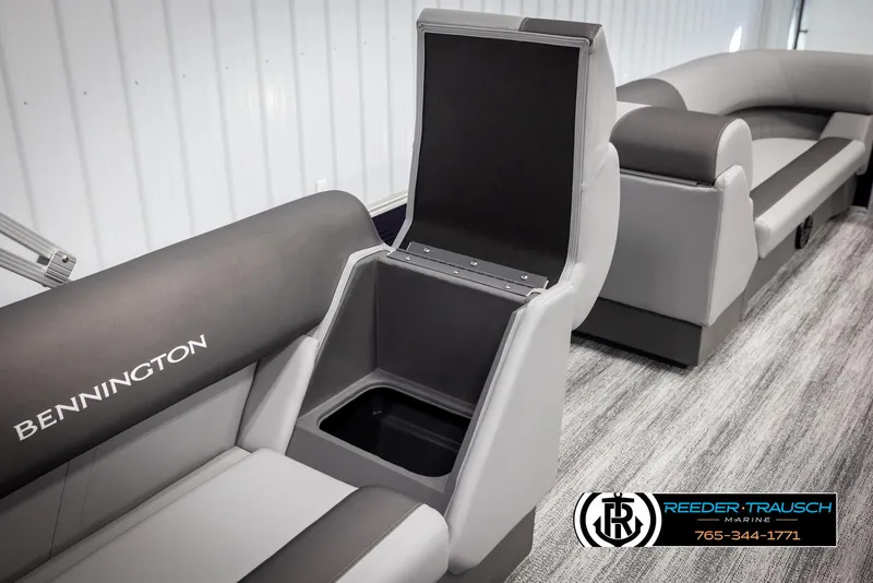 Slide: The Image of 2025 Bennington 21 SSRSE boat interior with open storage compartment, gray seating, and logo. - 23