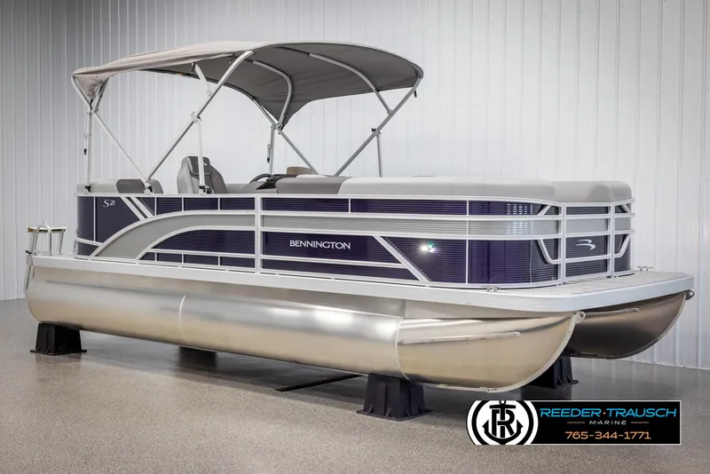 Slide: The Image of 2025 Bennington 21 SSRSE pontoon boat in showroom, featuring sleek design and canopy. - 3