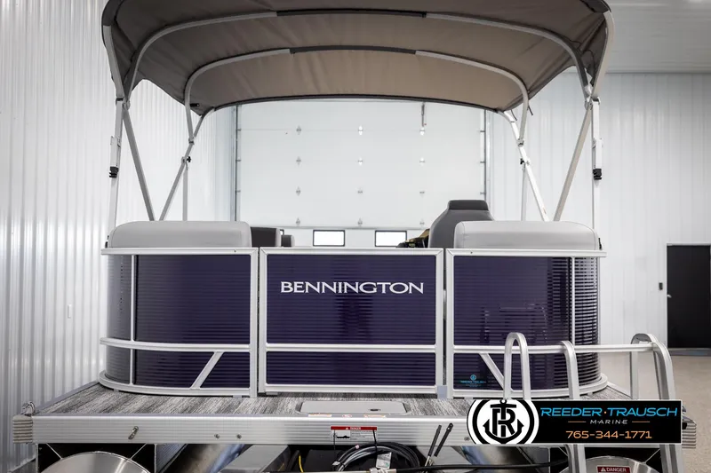 Slide: The Image of 2025 Bennington 21 SSRSE pontoon boat in showroom with canopy and branding. - 7