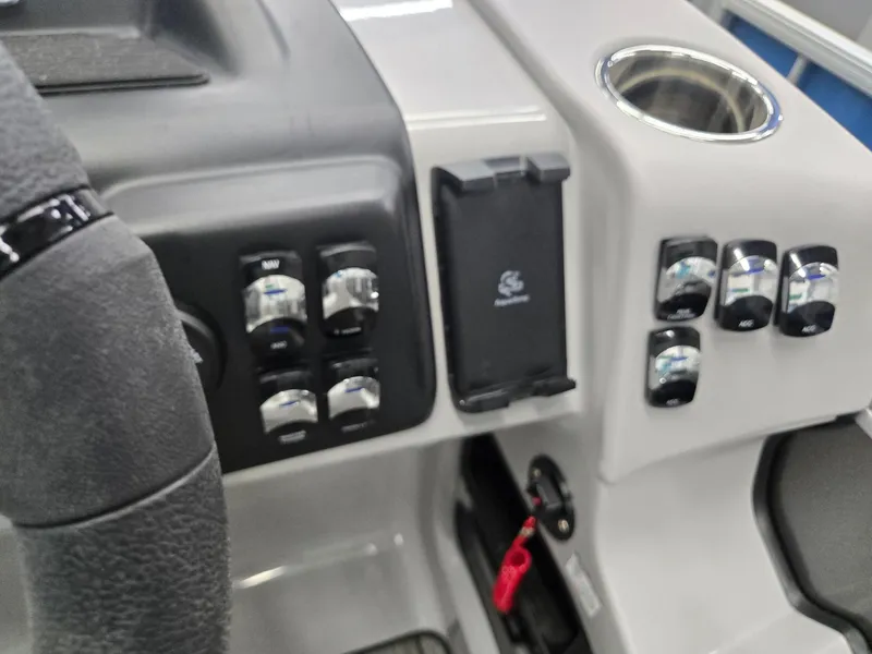 Slide: The Image of Control panel of 2025 Harris Cruiser 210 boat with switches and cup holder. - 11