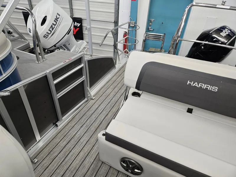 Slide: The Image of 2025 Harris Cruiser 210 boat interior with Suzuki outboard motor, featuring sleek seating and modern design. - 13