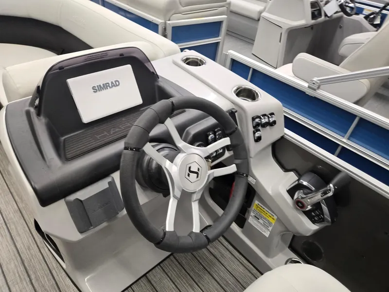 Slide: The Image of 2025 Harris Cruiser 210 boat dashboard with steering wheel and Simrad display. - 8