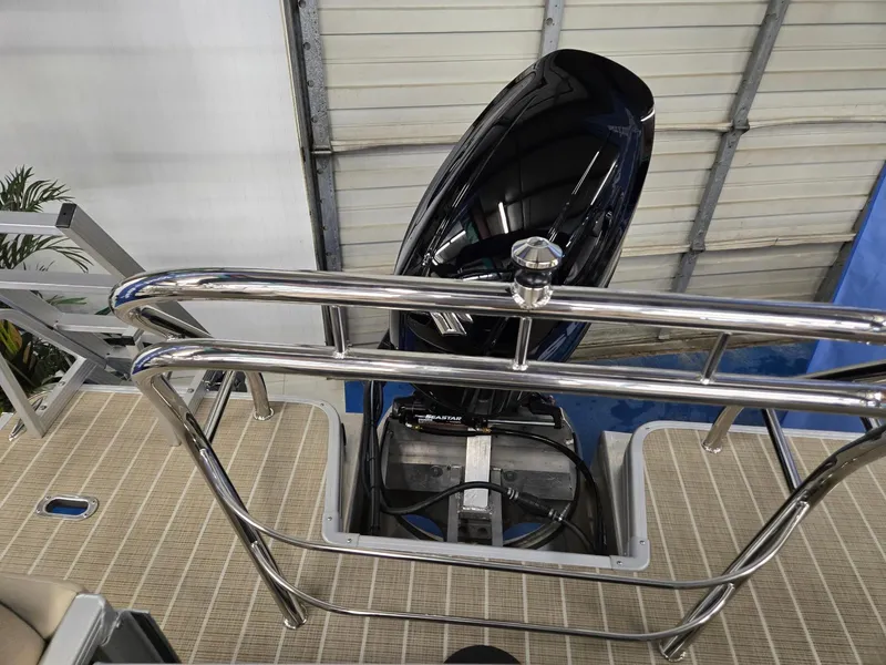 Slide: The Image of 2025 Godfrey SWEETWATER 2286 SB boat engine with stainless steel railing in a garage. - 16