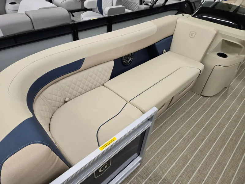 Slide: The Image of 2025 Godfrey SWEETWATER 2286 SB boat interior with beige and blue seating. - 2