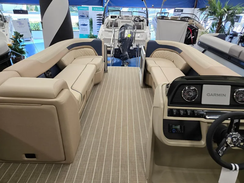 Slide: The Image of 2025 Godfrey SWEETWATER 2286 SB boat interior with beige seating and Garmin dashboard. - 22