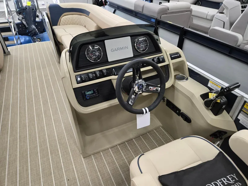 Slide: The Image of 2025 Godfrey SWEETWATER 2286 SB boat interior with Garmin dashboard and beige seating. - 24