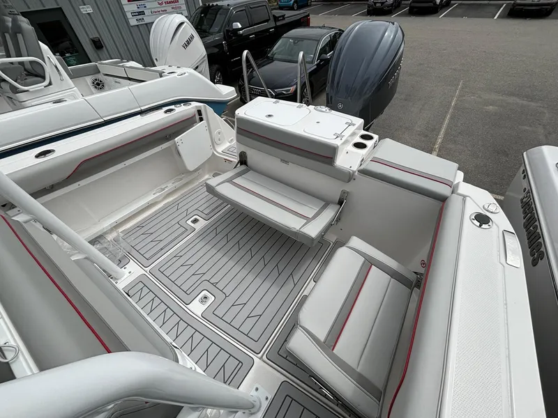 Slide: The Image of 2025 Solara S-250 CW boat interior with gray seating and deck, parked in a marina. - 10