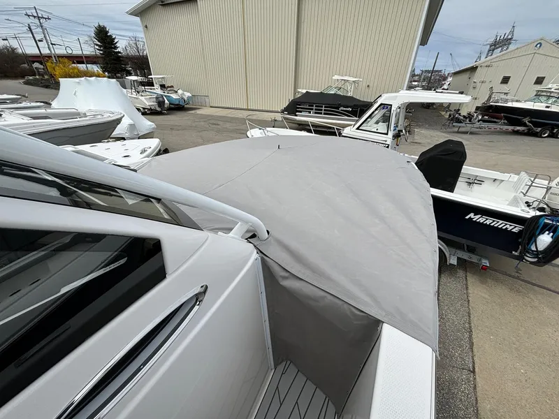 Slide: The Image of 2025 Solara S-250 CW boat with gray cover in a marina setting. - 13
