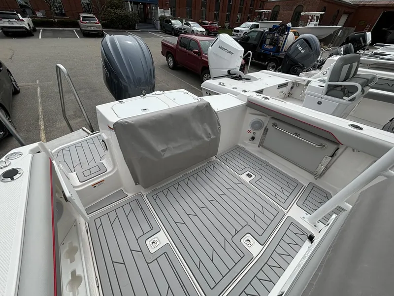 Slide: The Image of 2025 Solara S-250 CW boat deck with gray flooring and seating in a marina. - 24