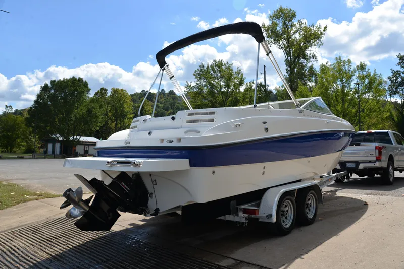 Slide: The Image of 2006 Bayliner 249 SD boat on trailer, parked outdoors under a clear sky. - 14