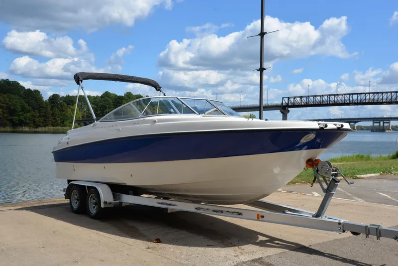 Slide: The Image of 2006 Bayliner 249 SD boat on trailer by a scenic lake. - 16