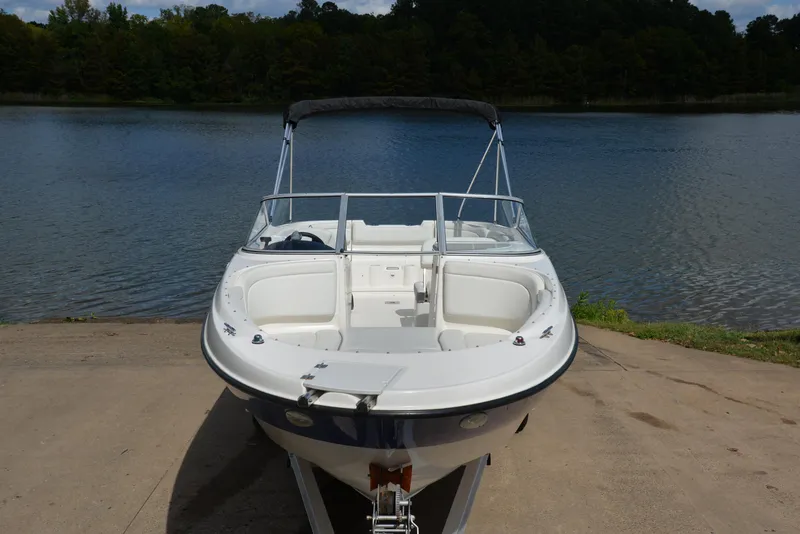 Slide: The Image of 2006 Bayliner 249 SD boat on trailer by a lake. - 17