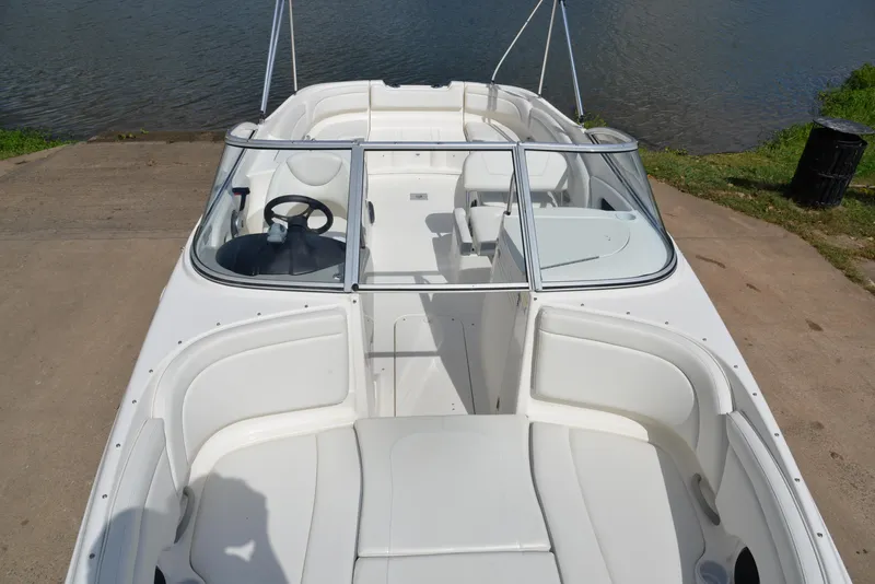 Slide: The Image of 2006 Bayliner 249 SD boat with white interior, docked by a lake. - 18