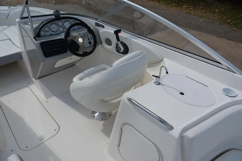 Slide: The Image of 2006 Bayliner 249 SD boat interior with steering wheel and seating area. - 21
