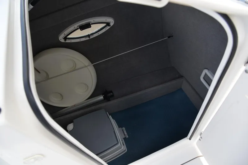 Slide: The Image of Interior storage compartment of 2006 Bayliner 249 SD boat, featuring a round hatch and storage box. - 23