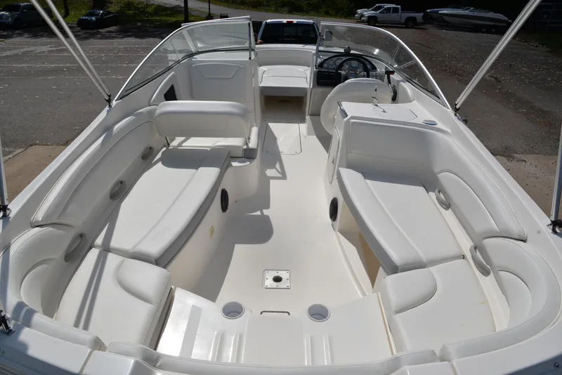 Slide: The Image of 2006 Bayliner 249 SD boat with spacious white seating and open deck layout. - 25