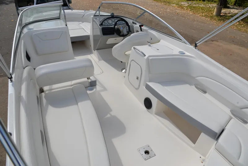 Slide: The Image of 2006 Bayliner 249 SD boat interior with white seating and steering console. - 27