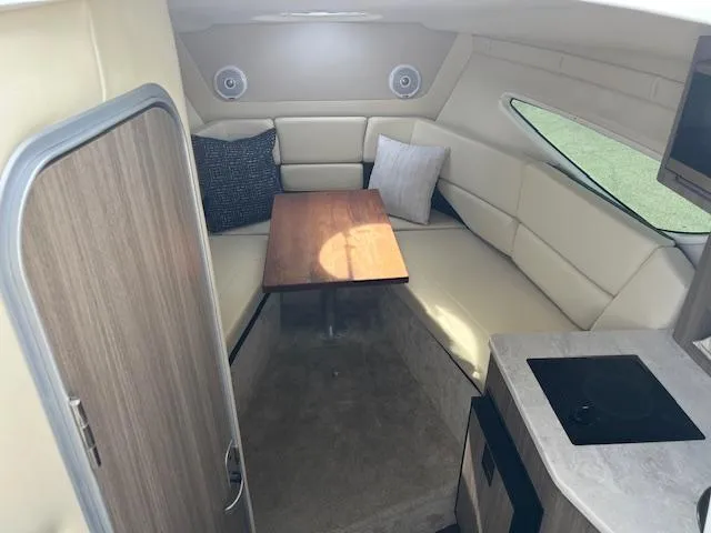 Slide: The Image of Interior of 2019 Regal 26 Express boat with cozy seating and table. - 11