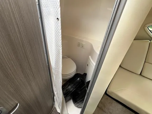 Slide: The Image of 2019 Regal 26 Express boat interior bathroom with toilet and seating area. - 15