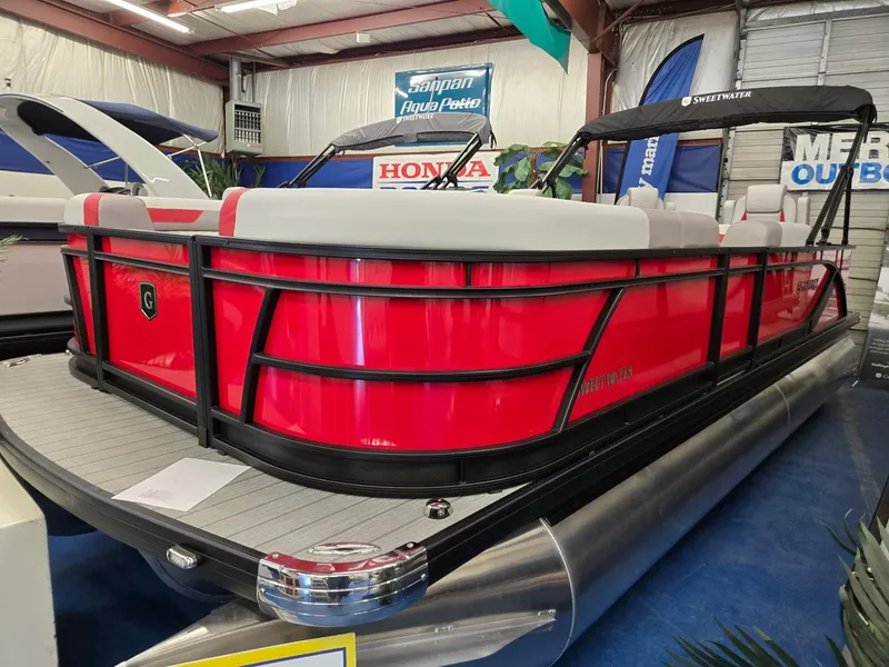 Slide: The Image of 2025 Godfrey Sweetwater 2286 FS pontoon boat in showroom, featuring vibrant red exterior. - 2