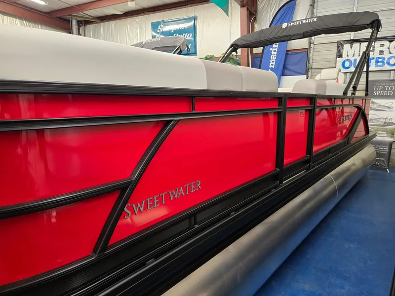 Slide: The Image of 2025 Godfrey Sweetwater 2286 FS pontoon boat with vibrant red exterior in showroom. - 3