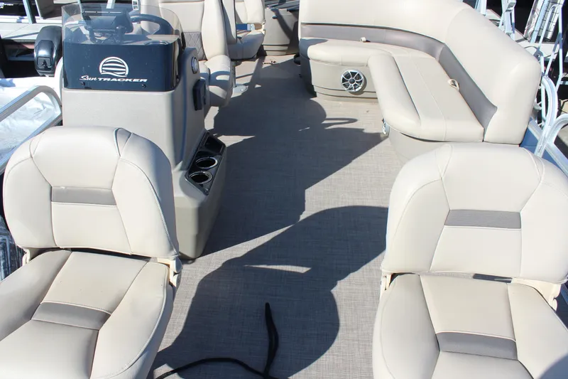 Slide: The Image of 2024 Sun Tracker BB18 boat interior with beige seating and steering console. - 10