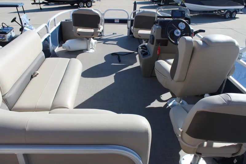 Slide: The Image of 2024 Sun Tracker BB18 pontoon boat interior with beige seating and steering console. - 16