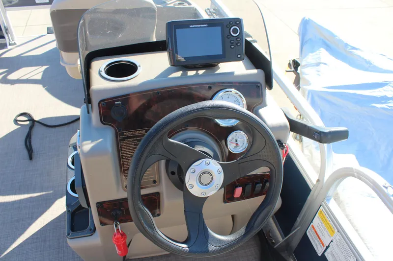 Slide: The Image of 2024 Sun Tracker BB18 boat dashboard with steering wheel and navigation system. - 6