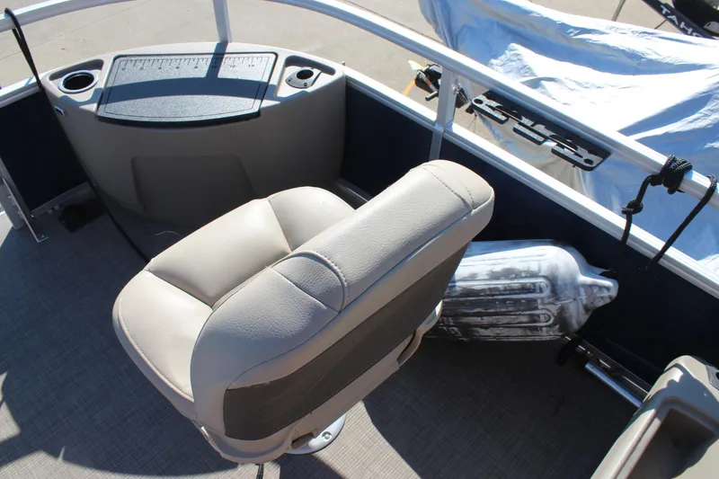 Slide: The Image of 2024 Sun Tracker BB18 boat interior with beige seating and control panel. - 9
