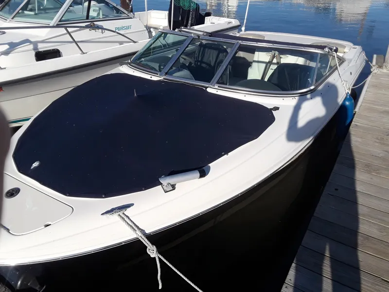 Slide: The Image of 2005 Sea Ray 200 SLX boat docked, covered with a black tarp, sunny day. - 4