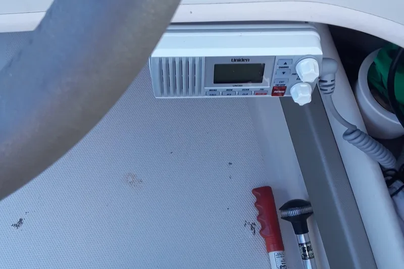 Slide: The Image of 2005 Sea Ray 200 SLX boat dashboard with radio and safety equipment. - 9