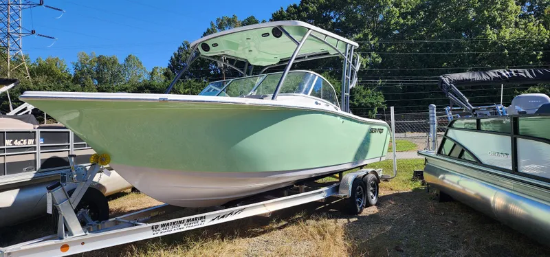 The Image of 2025 Sea Pro 240 Sport boat on trailer, light green hull, parked outdoors. - 1