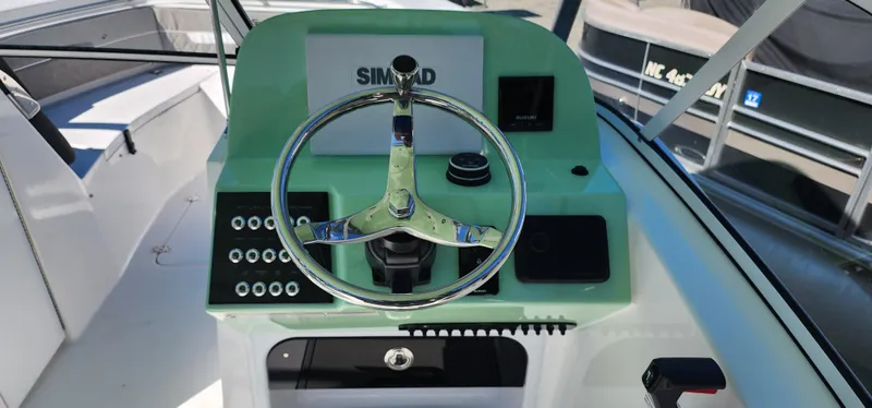 Slide: The Image of 2025 Sea Pro 240 Sport boat dashboard with steering wheel and controls. - 5
