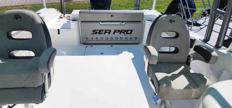Slide: The Image of 2025 Sea Pro 240 Sport boat interior with two cushioned seats and branded storage compartment. - 8