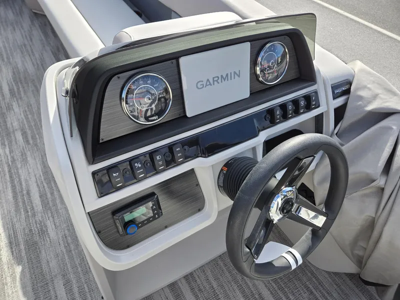 Slide: The Image of 2025 Godfrey Sweetwater 2286 C boat dashboard with Garmin navigation system and steering wheel. - 13