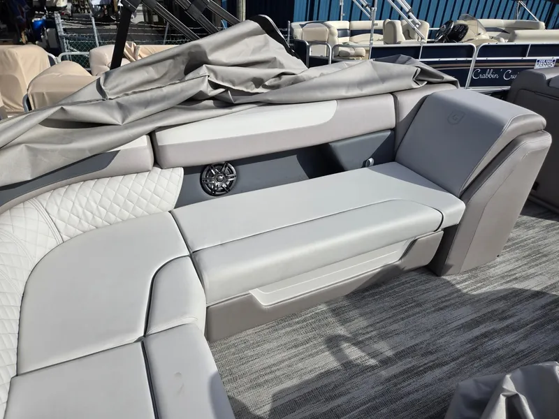 Slide: The Image of 2025 Godfrey Sweetwater 2286 C boat interior with gray seating and speaker. - 26