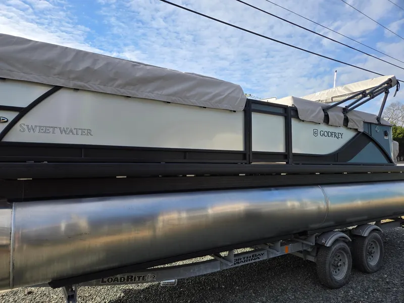 Slide: The Image of 2025 Godfrey Sweetwater 2286 C pontoon boat on trailer, covered and ready for transport. - 5
