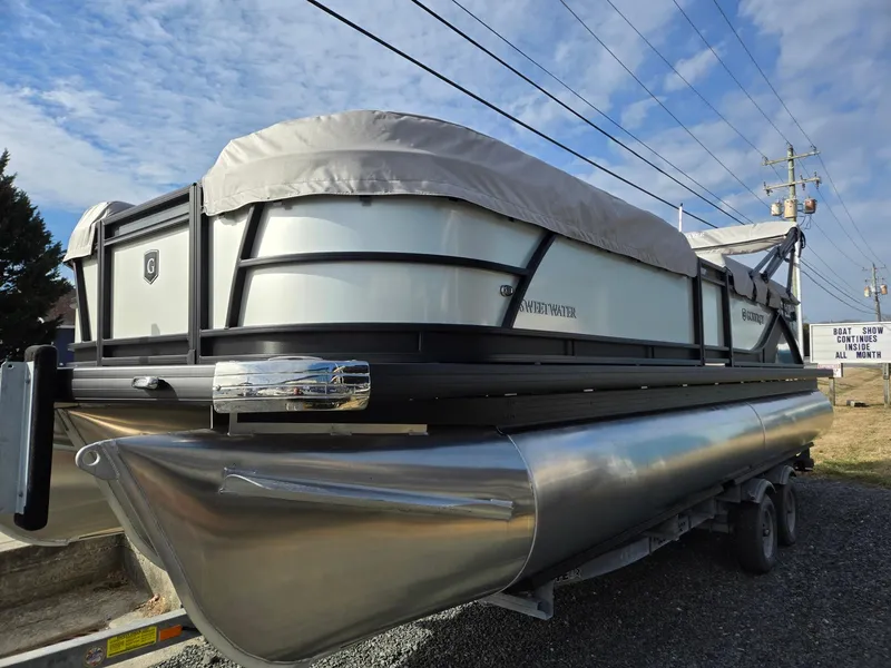 Slide: The Image of 2025 Godfrey Sweetwater 2286 C pontoon boat on trailer, covered and parked outdoors. - 6