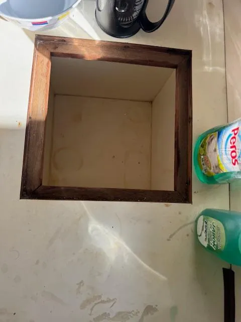 Slide: The Image of Open wooden compartment on a Cape Dory 36, 1980 model, with cleaning supplies nearby. - 13